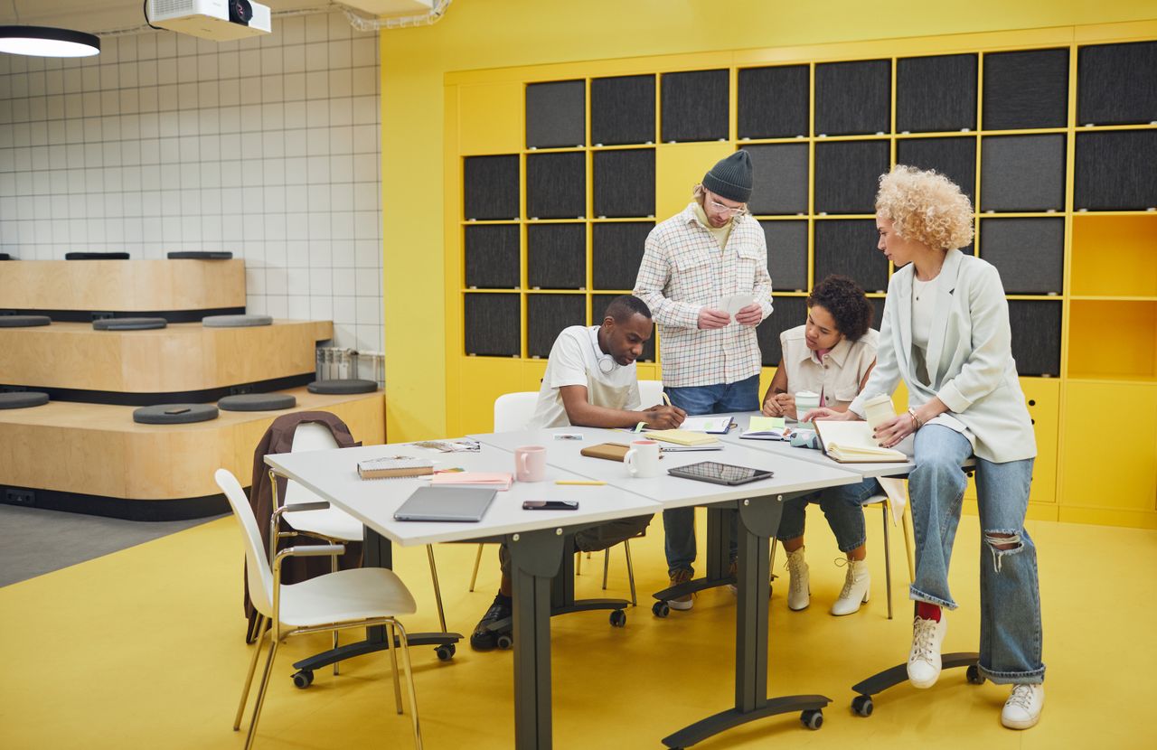Team members meeting together around a table in a bright, modern office